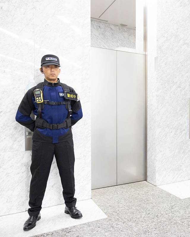 エレベーターの前で警備する警備員